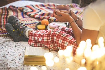 Woman lying on bed having breakfast on holidays. christmas cookies and and donut.  wishes new year