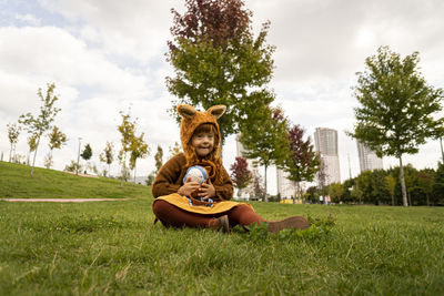 Girl with down syndrome sitting on grass in public park