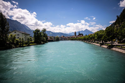 Scenic view of swimming pool by buildings against blue sky