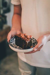 Midsection of woman holding pastry in plate