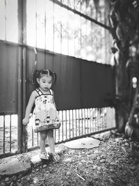 Cute girl standing against gate