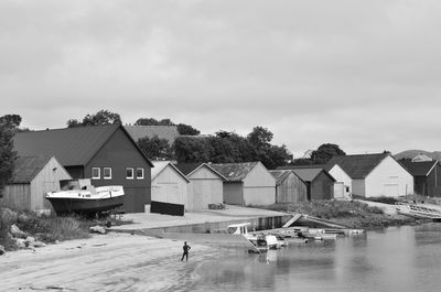 Houses by lake against sky