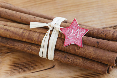 Bundle of cinnamon sticks with star shape tag on table