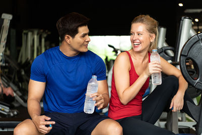 Young couple sitting in man holding camera