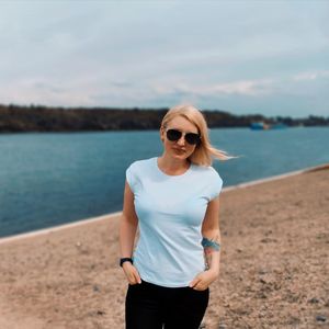 Portrait of woman wearing sunglasses standing at beach