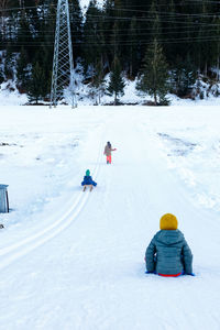 Three children going down the snow hill