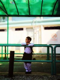 Full length of woman standing against railing