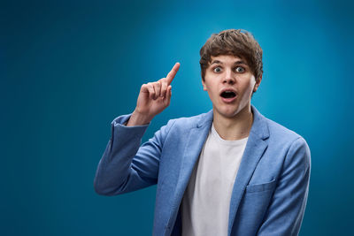 Portrait of young man against blue background