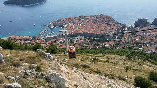 High angle view of cityscape by sea against sky