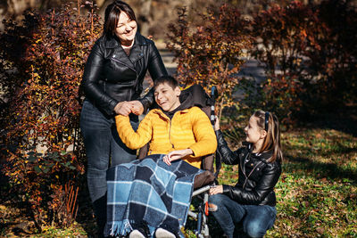 Diversity and inclusion. happy family, mother, daughter and son teen boy with cerebral palsy