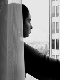Side view of thoughtful teenage girl standing in balcony