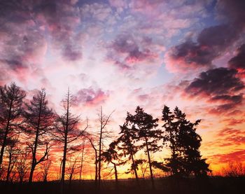 Silhouette landscape against dramatic sky during sunset
