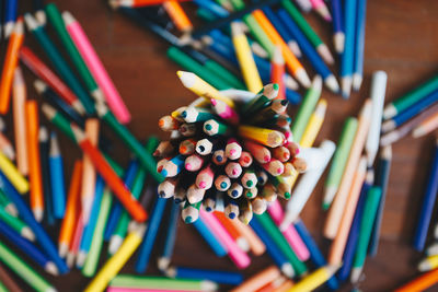 Close-up of multi colored pencils in cup on table