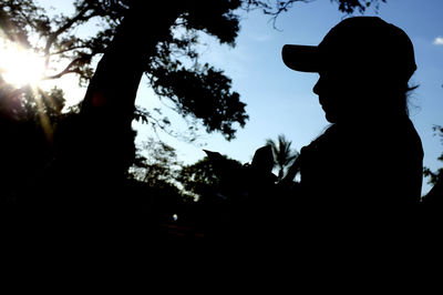 Silhouette man and woman against sky during sunset