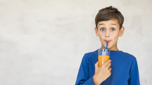 Portrait of boy drinking against clear sky