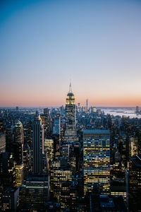 Illuminated cityscape against clear sky