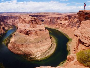 Man standing on rock by horseshoe bend