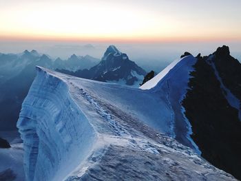 Scenic view of snow covered mountains against sky during sunset