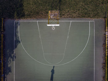 Drone view of a basketball court with player shadow in pavia, italy