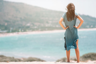 Rear view of woman standing at beach