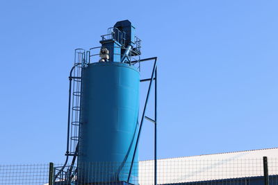 Low angle view of crane against clear blue sky