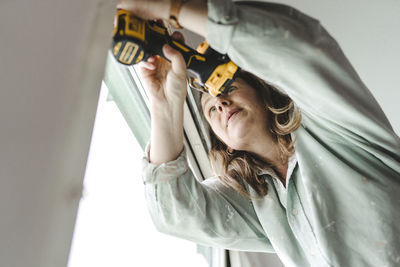 Woman using electric drill