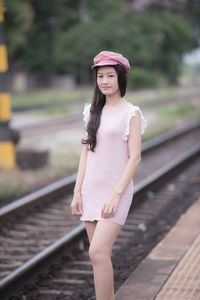 Portrait of woman standing on railroad track