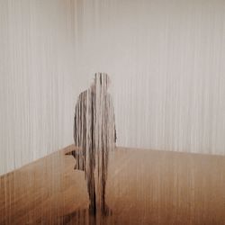 Woman standing behind curtain in an empty room