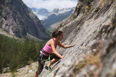 Woman standing on rock against mountains