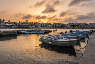 Boats in harbor at sunset