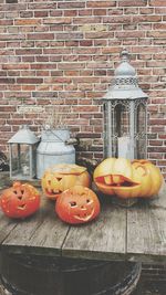 View of pumpkins on table against brick wall