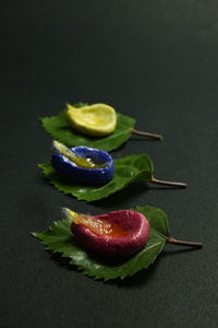 Close-up of fruits served on table against black background