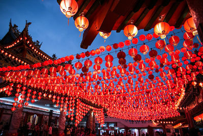 Low angle view of illuminated lanterns hanging against sky