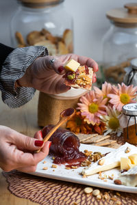 Cropped hand of person preparing food on table