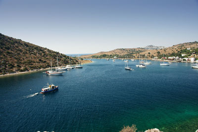 Sailboats on sea against clear sky