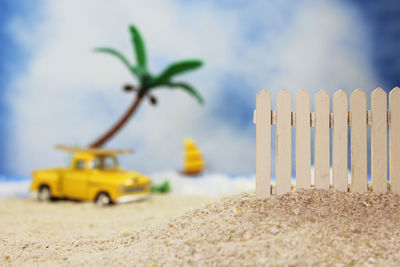 Close-up of yellow toy car on sand