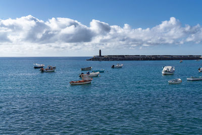 Sailboats in sea against sky