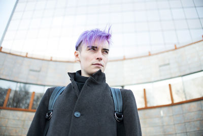 Low angle view of homosexual man looking away while standing outdoors