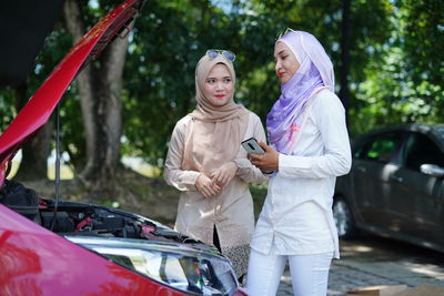 Full length of woman standing against car