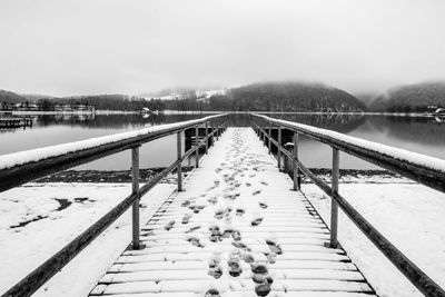 Pier over lake against clear sky during winter