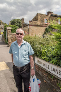 Portrait of man standing against built structure