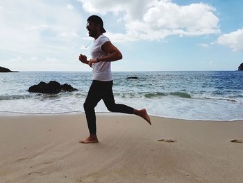 Full length of man standing on beach against sky