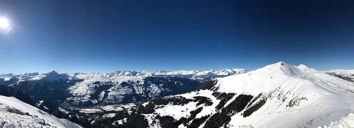 Scenic view of snowcapped mountains against clear blue sky