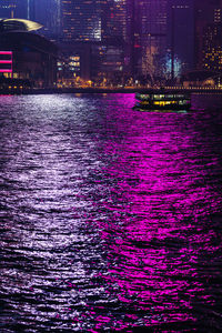 Illuminated bridge over river against sky during sunset