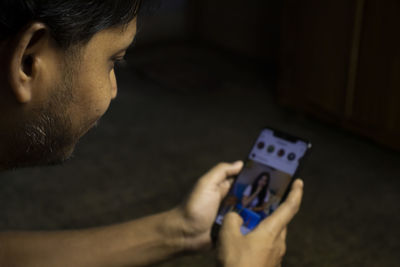 Close-up portrait of young man using mobile phone whatsapp