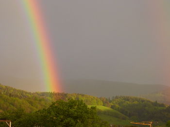 Scenic view of rainbow over mountain against sky