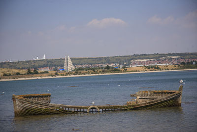 Boats in sea with buildings in background