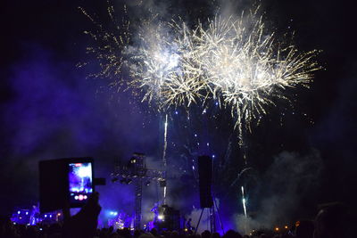 Low angle view of firework display at night