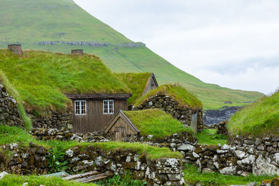 Built structure on land by mountain against sky