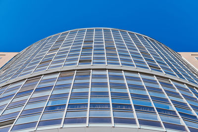 Low angle view of modern building against clear blue sky